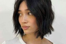a black choppy bob with central part and waves is a classy idea to rock, it looks soft and cool
