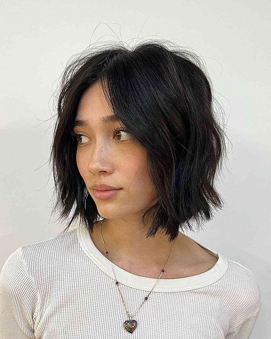 a black choppy bob with central part and waves is a classy idea to rock, it looks soft and cool