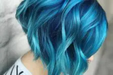 a bold navy angled chopped bob with turquoise balayage and waves is a super catchy and chic idea