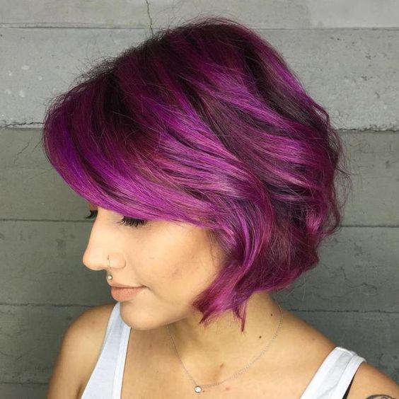 a bright purple chin-length bob with waves and side bangs and volume is a chic and cool idea with a bright touch