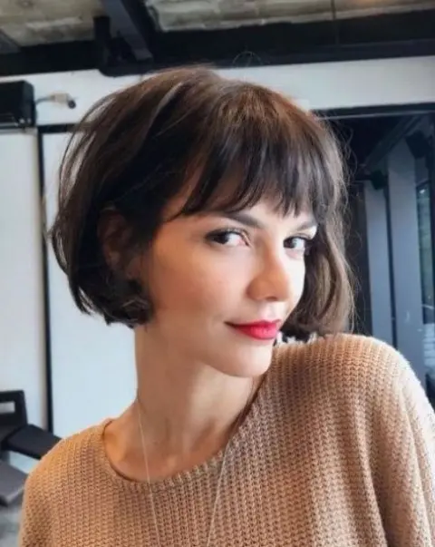 a brown French bob with bangs and waves is a classic French hairstyle that many stylish Parisian girls have tried