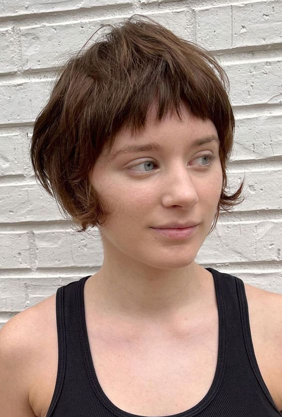 a brown bixie with a layers and textured touches, a short fringe and curved ends on the sides is cute