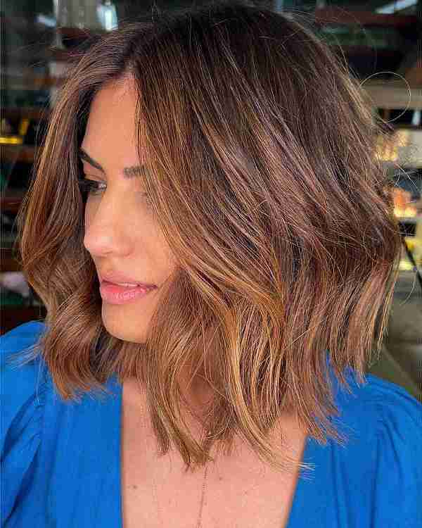 a brown layered long bob with caramel balayage and a darker root, with texture and a contrasting look
