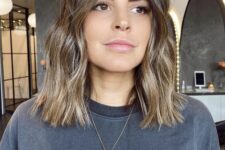 a brown outgrown bob with blonde balayage, with waves and central part is a chic and cool idea for trying now