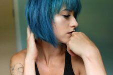 a catchy and bold teal angled chin-length bob with bangs is a stylish idea for a statement-like look