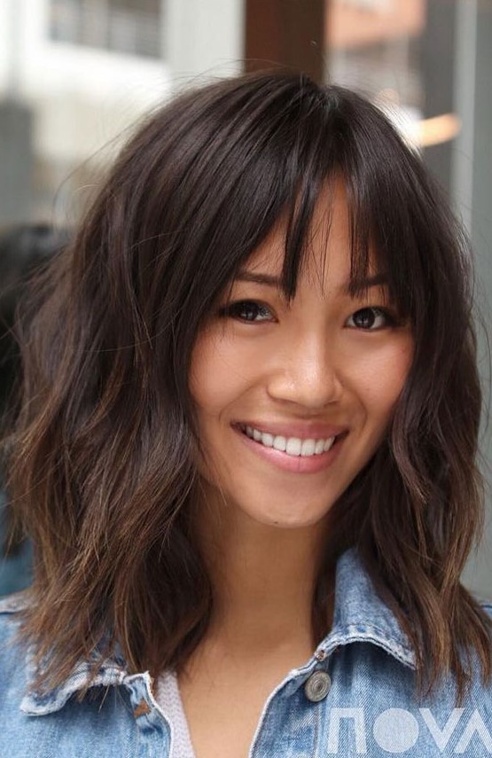 a cute layered outgrown bob with bottleneck bangs and a rich brown tone is a very chic and cool idea for a wearing now