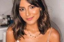 a dark brown outgrown bob with curtain bangs and touches of softer and warmer brown is a beautiful idea, add waves for a girlish feel