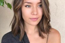 a delicate brown outgrown bob with side part and caramel balayage, with a bit of waves is a chic and cool idea