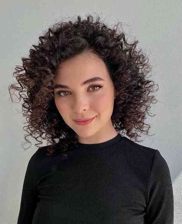 a frizzy curly long bob shows off the texture and the beauty of the curls and makes them look healthier