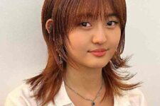 a ginger octopus haircut with wispy bangs, this haircut gives movement keep length at the same time