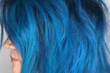 a gorgeous bright blue chopped bob with a darker root and messy waves is a stylish and cool idea to go for