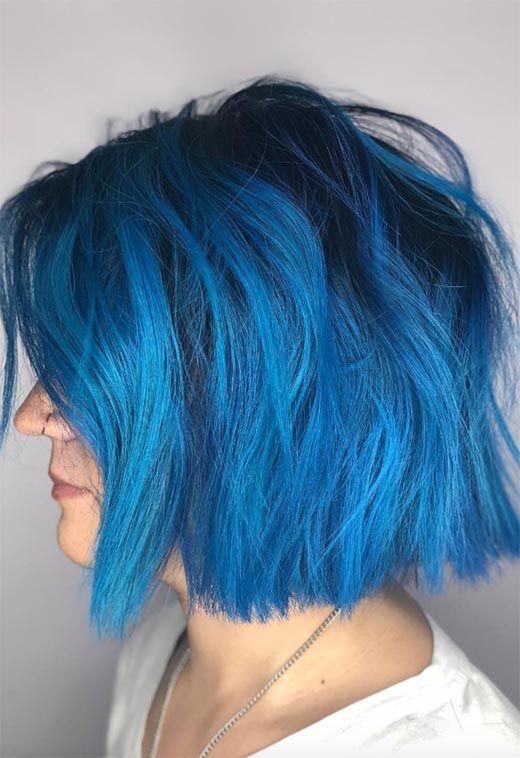 a gorgeous bright blue chopped bob with a darker root and messy waves is a stylish and cool idea to go for