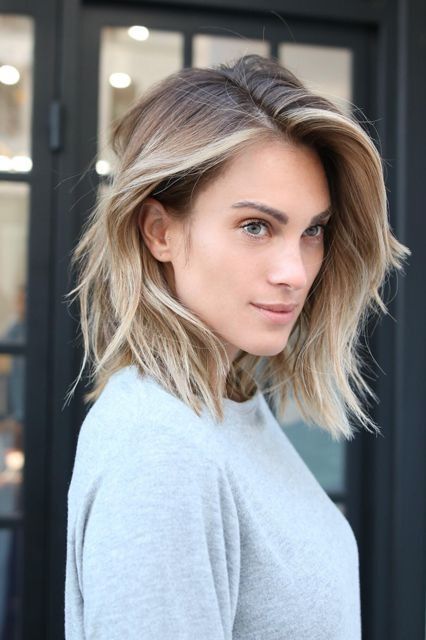 a layered long bob with blonde balayage and a darker root, with plenty of volume and texture, looks messy yet cool