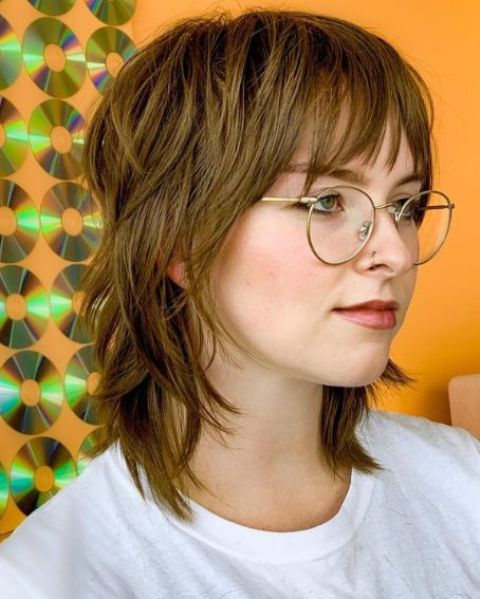 a light medium length brown wolf cut with wispy bangs and layers is a catchy and cool idea for today