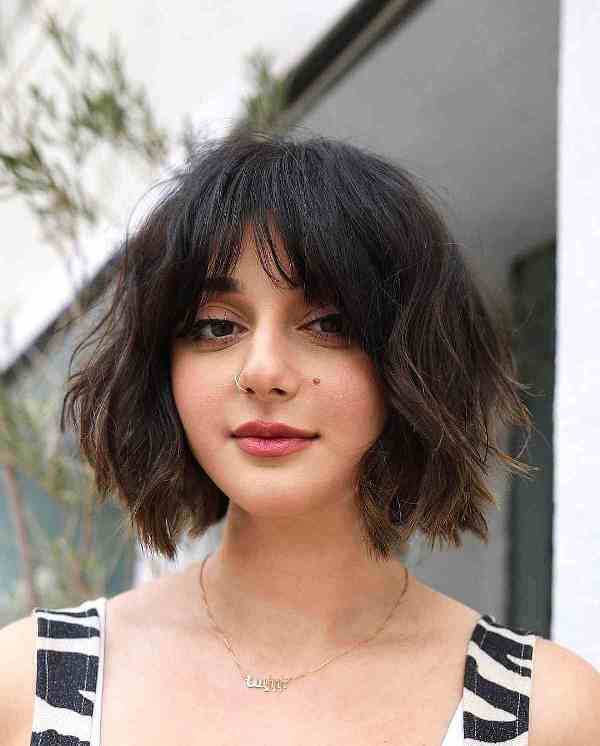 a lived in French bob in black and light brown with a lot of texture and bottleneck bangs is a cool idea