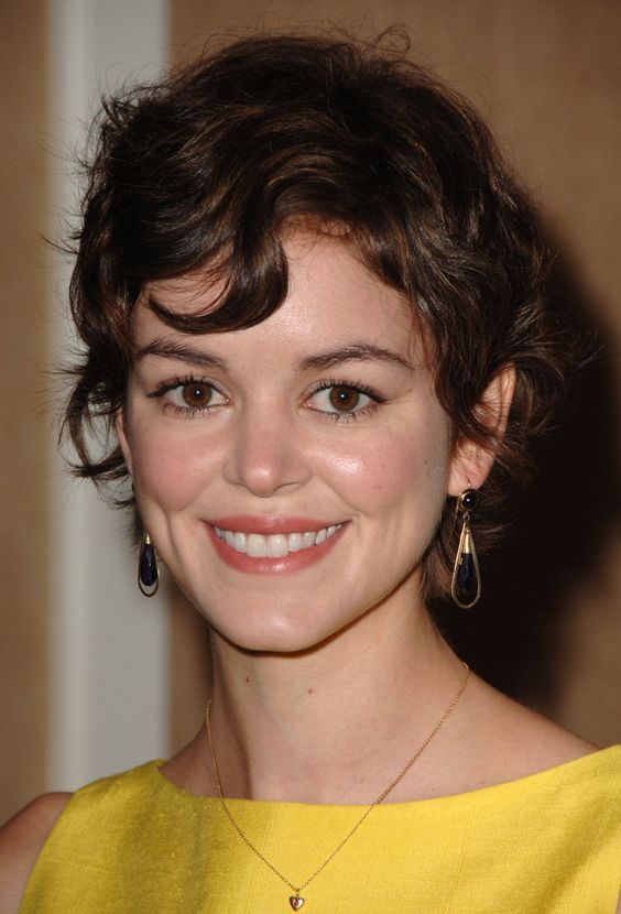 a lovely and messy brown wavy pixie with a bit of bangs is a cool and cute idea that looks Paris inspired