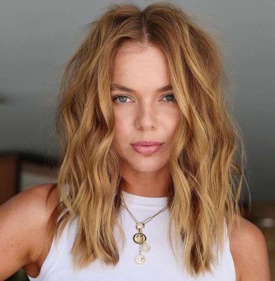 a lovely honey blonde textured wavy medium-length hairstyle with a lot of volume is a beautiful idea for summer