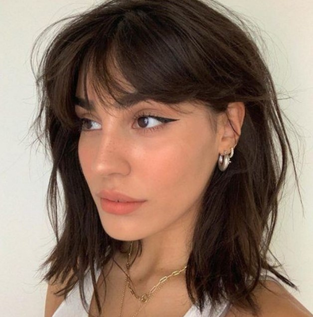 a messy dark brown collarbone bob with messy bangs and plenty of texture is a pretty and feminine idea