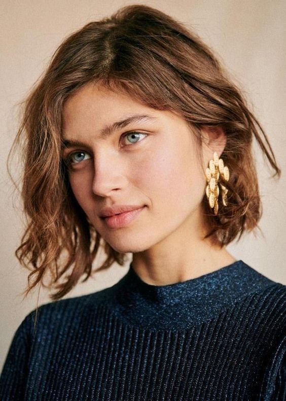 a messy wavy extural brown chin length bob, with a messy part is a cool idea for a super natural and pretty look