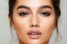 a nude makeup with a nude lip, highlighter, fluffy eyebrows and blush plus accented eyes is a cool and catchy idea