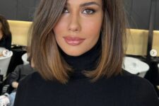 a pretty mousy brown collarbone bob with a bit of caramel highlights, side part and a lot of volume looks very chic
