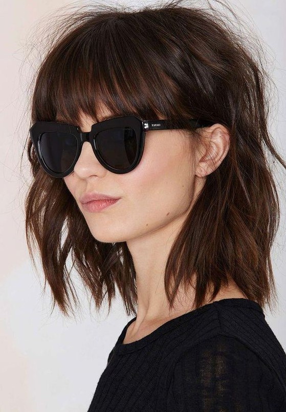 a shaggy brown shoulder-length collarbone bob with classic bangs and messy waves is a very rock-n-roll idea to rock