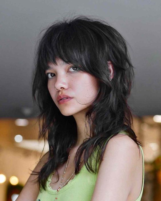 a shaggy wolf cut in black, with bangs and messy waves is amazing for those who have thick hair