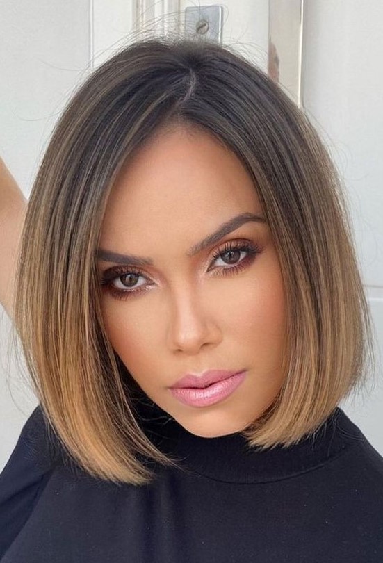 a stylish and elegant brunette chin length bob with an ombre effect with a caramel shade and side part