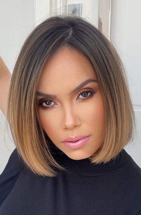 a stylish and elegant brunette chin length bob with an ombre effect with a caramel shade and side part