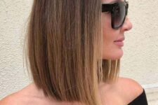 a stylish and sleek brown collarbone bob with blonde balayage and central part plus enough volume is cool