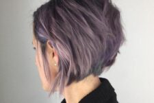 a stylish lavender angled bob with a lot of volume and texture and a darker root looks slight and delicate