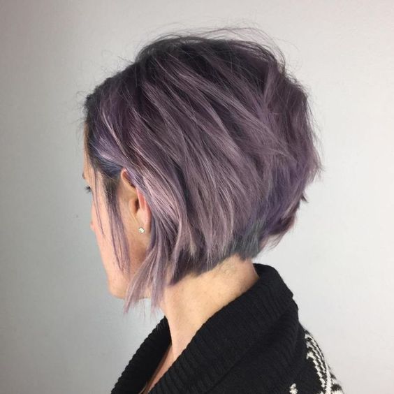 a stylish lavender angled bob with a lot of volume and texture and a darker root looks slight and delicate