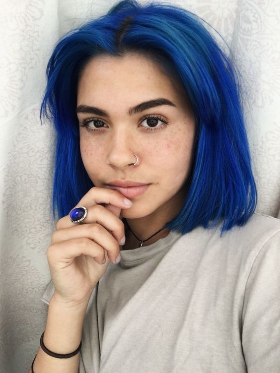 a super bold blue bob with a darker root and curtain bangs plus volume is a super edgy and bright idea