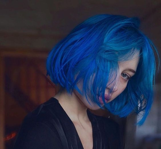 a super bold blue chin-length bob with a lot of volume and textured hair plus short curtain bangs is awesome