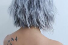 a very pale blue midi angled bob with a darker root and a bit of texture looks very messy and still very eye-catching