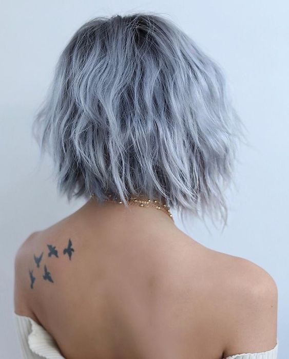 A very pale blue midi angled bob with a darker root and a bit of texture looks very messy and still very eye catching