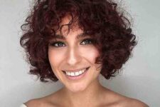 a very short burgundy to purple curly haircut with bangs is a very beautiful and catchy idea
