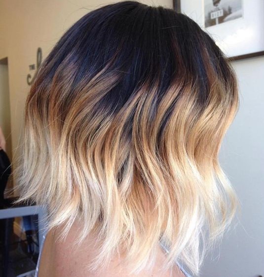 a wavy long bob with black to caramel and bleached blonde, with a lot of volume is super bold