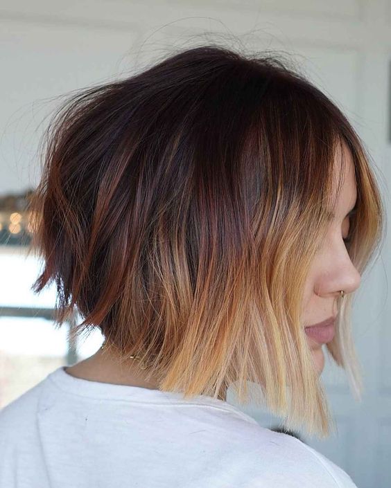 an auburn angled bob with caramel and blonde shades and waves is a super contrasting and bold idea