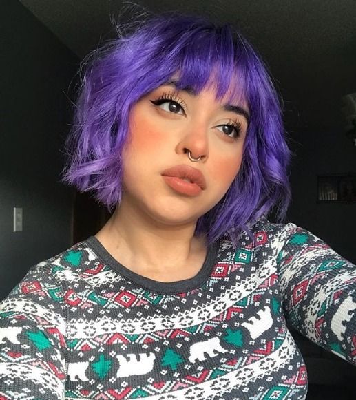 an edgy violet chopped chin-length wavy bob with wispy bangs is a catchy and lively solution with a gorgeous shade