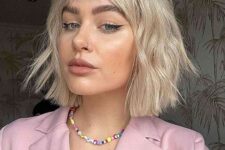 an eye-catchy textural and wavy blonde choppy bob with wispy bangs is a cool idea that looks trendy and fresh