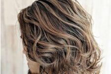 beautiful brown shoulder-length wavy hair with caramel balayage that imitates sun-bleached locks looks jaw-dropping