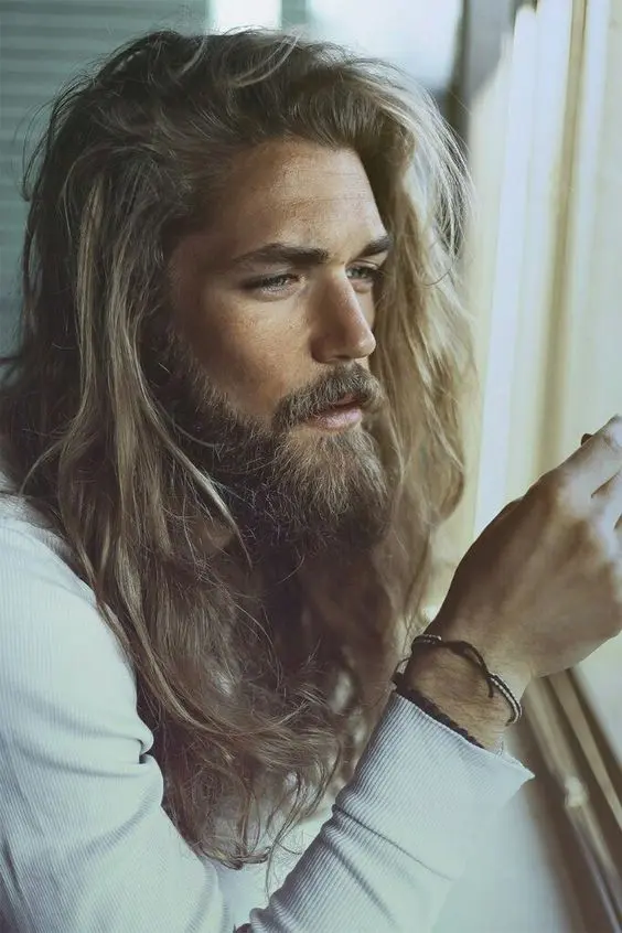 beautiful light blonde long hair with texture and waves plus a full beard create a very cool look for summer
