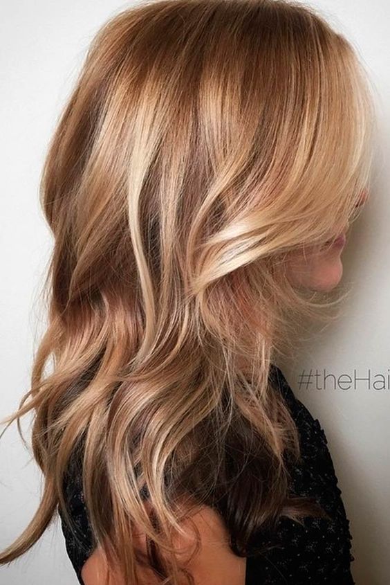 Hermoso cabello largo y castaño claro con balayage y ondas rubio dorado y miel, además de un acabado brillante, es una idea increíble con mucha elegancia.