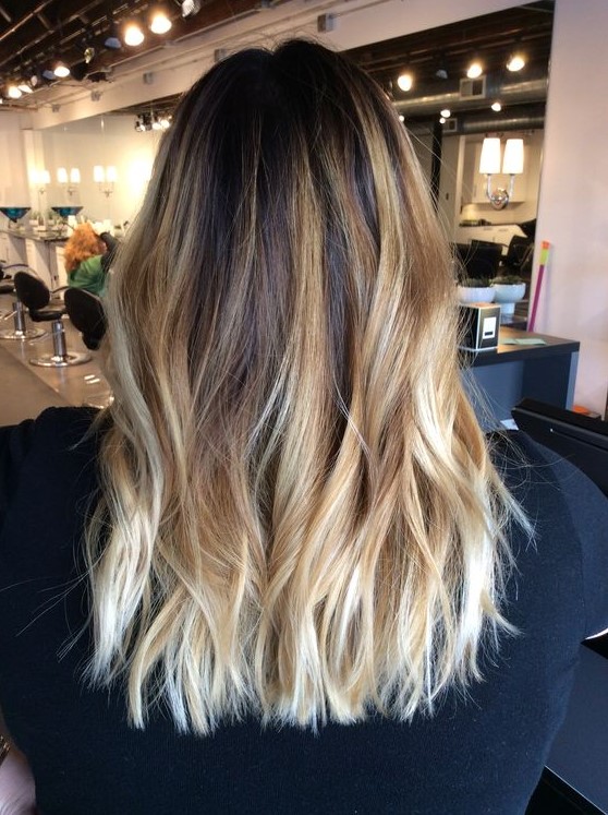 dark brown roots and intense gold and honey blonde balayage for a bold and eye-catchy look