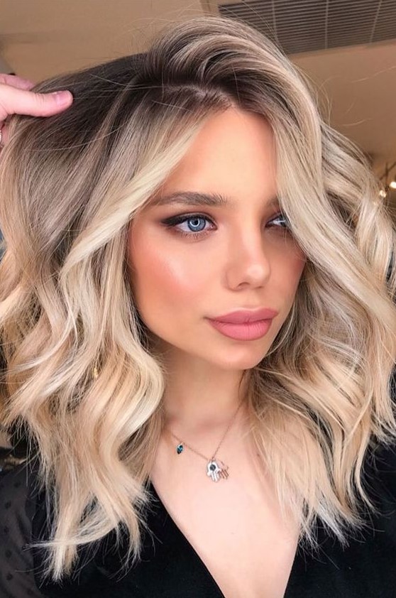 gorgeous rooty honey blonde wavy hair with mixed shades of blonde that looks very natural and very chic