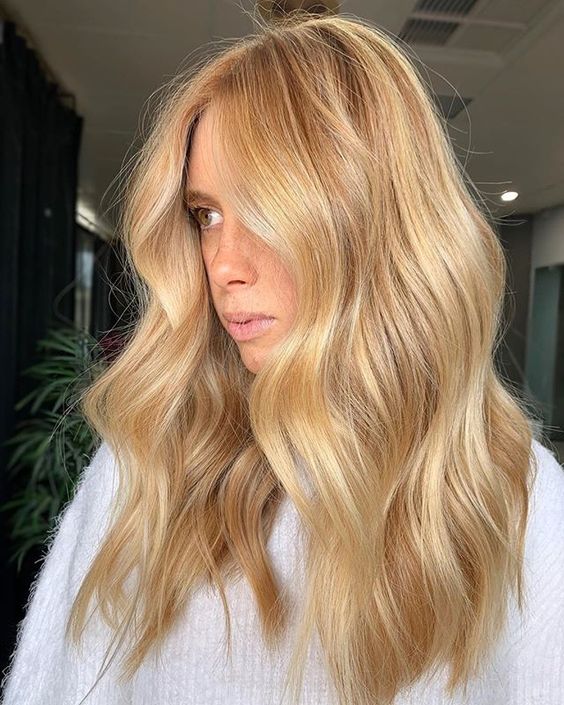 long and chic gold blonde wavy hair with central part is a very chic and beautiful idea to rock