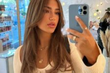 long brown hair with a cascade effect, a caramel balayage and long curtain bangs is a gorgeous idea
