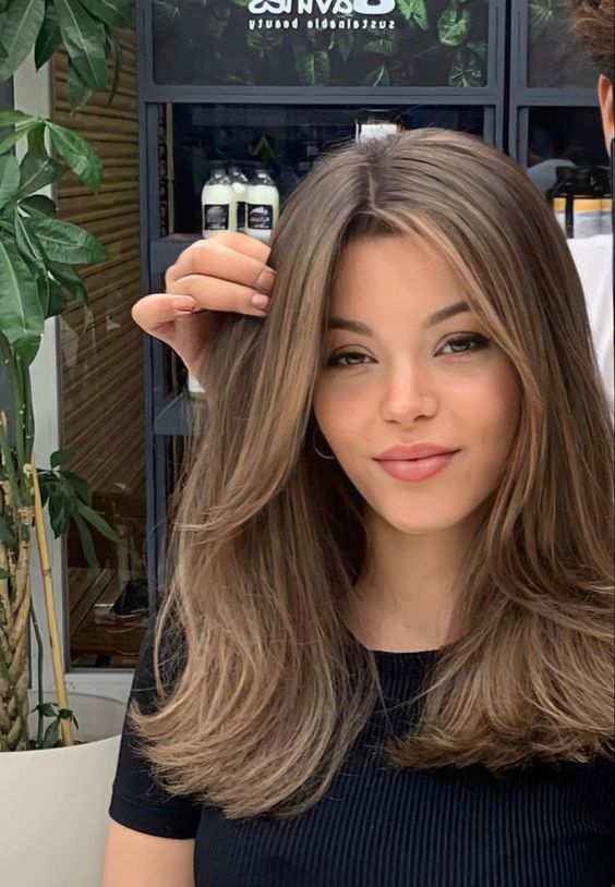long brunette hair with caramel highlights and chin bangs is a solution that always works
