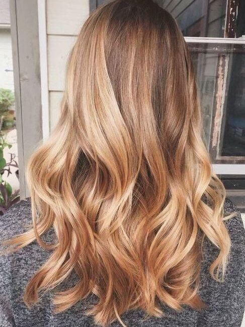 El cabello largo y moreno con balayage y ondas rubio dorado y miel es una idea elegante y encantadora para probar en el verano.